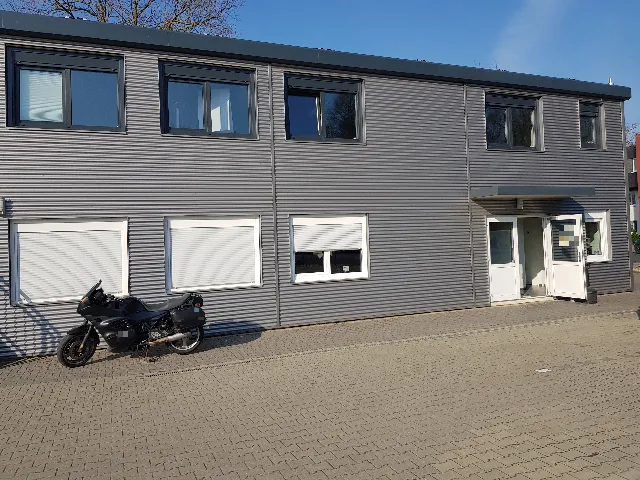 Zweigeschossiges Bürogebäude mit grauer Wellblechfassade