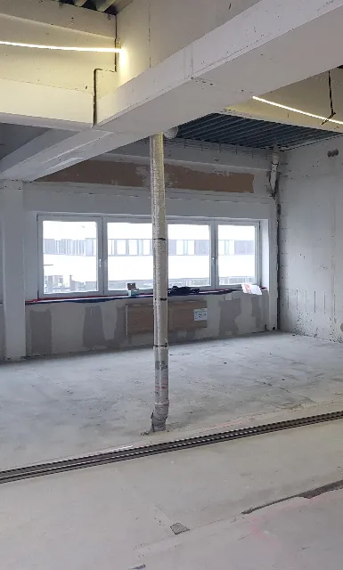 Büroetage im Umbau mit offenen Decken und Baumaterial